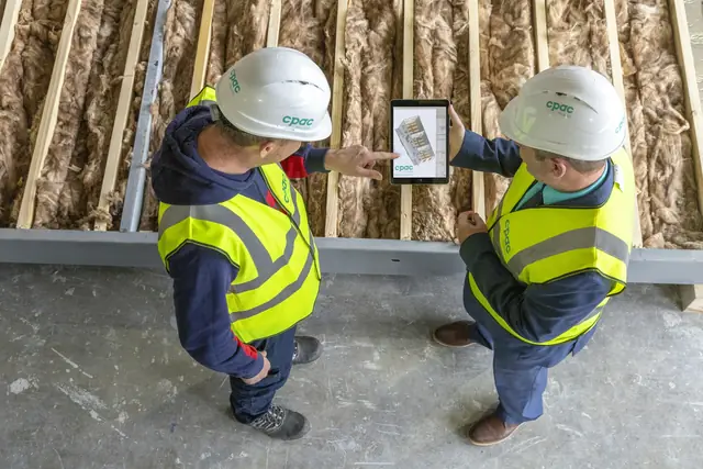 Two workers reviewing plans on a tablet